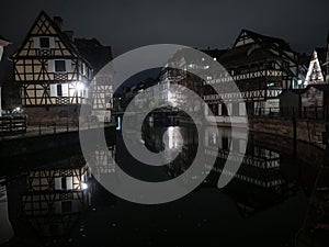 Illuminated traditional half-timbered buildings at Petite France Ill Rhine river Strasbourg Grand Est Alsace at night