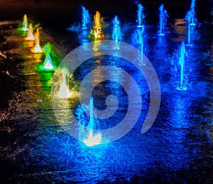 Illuminated waterspout fountain at night