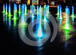 Illuminated waterspout fountain at night