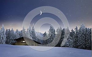 Illuminated wooden hut in a winter night