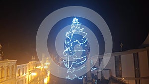 Illuminated Xmas tree during a severe wind storm. Lighted Christmas tree during a strong wind gale