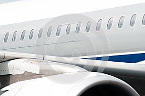 Illuminators of an airplane on the fuselage, a view over the engine and the wing.