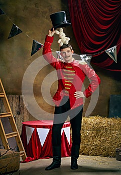 Illusionist. Vintage portrait of male retro circus entertainer expresses rejoice and announces start of show over dark