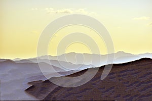 Illustrated photo of mountain range silhouettes with color desaturation.