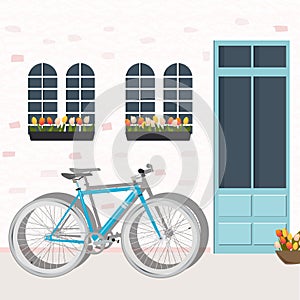 Illustration of a blue bicycle in flat style on a background of a pink wall with windows, tulips and a door.