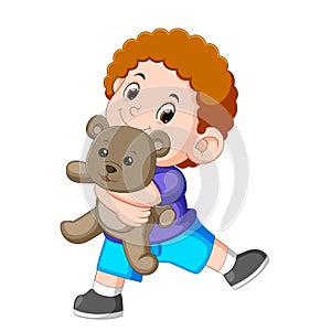 A boy happy play with the grey teddy bear