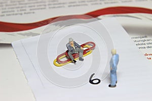 Illustration, different perspective makes another value, sitting at paperclip and standing businessman mini figure toys facing