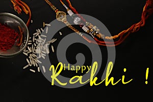 Illustration of Happy Rakhi with rakhi threads and rice on black background