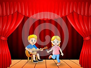 Little boy playing guitar and singing girl dancing