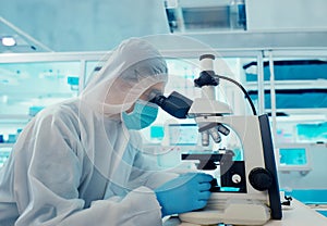 Illustration of scientist in a lab coat examines a sample under a microscope amidst various lab equipment. A scene of scientific