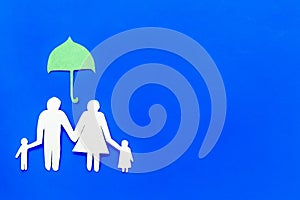 Illustration of social security concept. Financial protection. Family silhouette, cutout under umbrella on blue