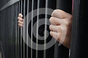 Illustration of someone`s hand in prison