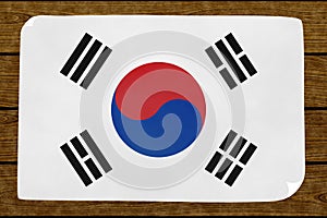 Illustration of a South KoreasÂ´s flag painted on the papier pasted on the woody wall