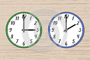Illustration of two wall clocks on wood. The green one symbolizes summer, the blue one winter.