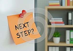 orange sticky note on office desk realistic next step