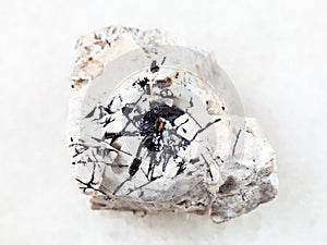 Ilmenite black crystals on rough stone on white photo