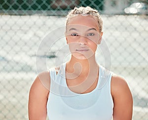 Im dedicated to being the best. an attractive young woman standing alone outside during tennis practise.