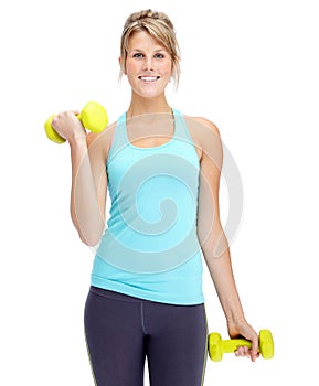 Im getting into shape. Attractive young woman in sportswear lifting dumbbells while isolated on white.