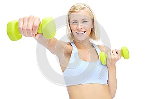 Im getting in shape. Sporty young woman lifting dumbbells while isolated on white.