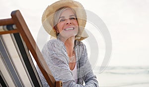 Im so grateful for days such as this. an attractive senior woman relaxing on a lounger on a summers day at the beach.