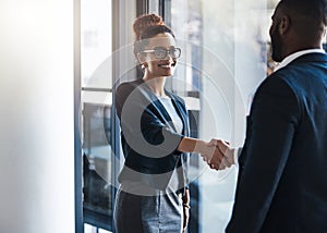 Im happy we could finally meet face to face. two businesspeople shaking hands in an office.