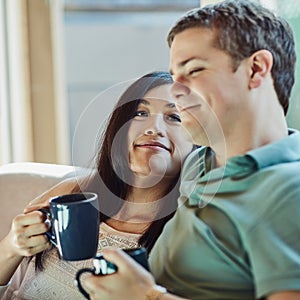 Im so happy by his side. a happy young couple relaxing on their couch at home.