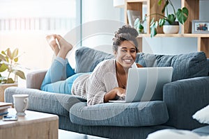 Im always happy when I get time to blog. Full length portrait of a happy young woman using her laptop while laying on