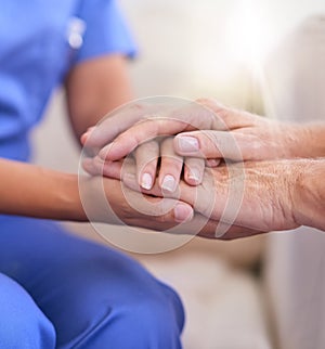 Im here to help. Cropped shot of a nurse holding a senior womans hands in comfort.