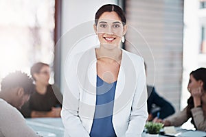 Im here to lead. Portrait of a businesswoman in an office with her colleagues in the background.