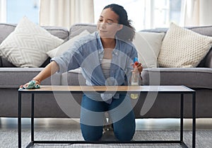 Im really impressed with how this cleaner performs. a young woman cleaning down her wood coffee table at home.
