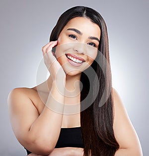 Im indeed having a fab hair day. Studio portrait of an attractive young woman posing against a grey background.