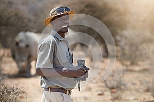 Im living my career dream. Portrait of a confident game ranger looking at a group of rhinos in the veld.
