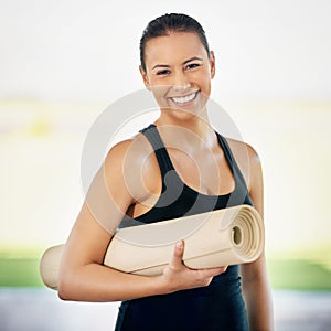 Im on my way to yoga. Cropped portrait of a young woman carrying her exercise mat on the way to yoga.