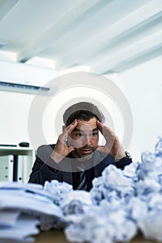 Im never going to get through all of this. Shot of a stressed out businessman sitting at his desk overwhelmed by