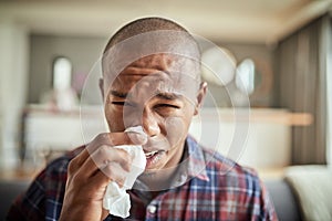 Im really not in the mood to go to work today. Portrait of an uncomfortable looking young man holding a tissue in front