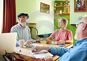 Im open to your suggestions. three seniors having a meeting around a table at home.