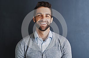 Im proud of all my achievements. Portrait of a handsome young businessman posing against a dark background.