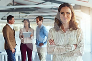 Im proud to be a part of this team. Portrait of a confident businesswoman posing in the office while her colleagues