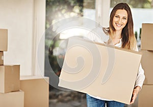 Im ready to start my brand new life. Cropped portrait of an attractive young woman carrying a box on moving day.