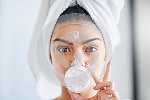 Im sharing all my beauty secrets with you. Portrait of a beautiful young woman applying moisturizer to her skin in the