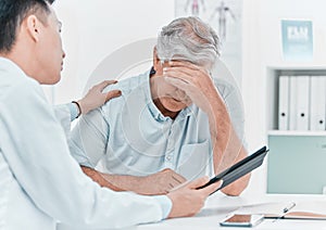 Im sorry to be the bearer of bad news. a mature man sitting and being comforted by his doctor during a consultation in