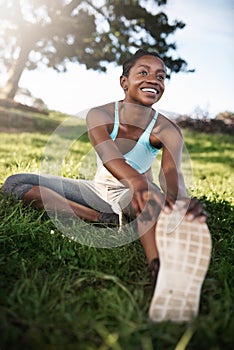 Im stretching my lifespan. a young woman stretching before her run.