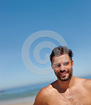 Im a sun worshipper. a young man enjoying a day at the beach. photo