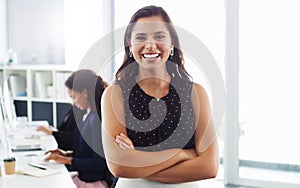 Im a take charge leader. Portrait of a confident young businesswoman working in a modern office with her colleague in