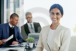 Im on top of my game. Portrait of a businesswoman in an office with her colleagues in the background.