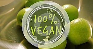 Image of 100 percent vegan text banner against close up of green apples