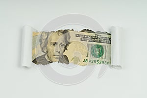 An image of a 20 dollar bill is visible in the torn hole of a sheet of paper