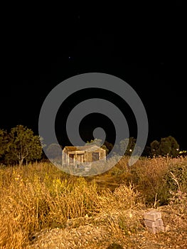 image of an abandoned house at a starry night in a dried wheat field