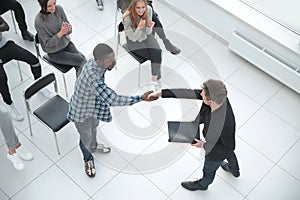 Image from above of business people sitting around conference de