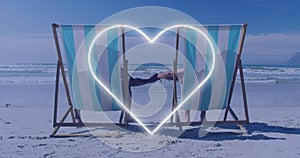 Image of african american couple lying at beach over heart